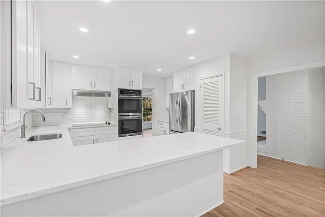 a kitchen with stainless steel appliances a refrigerator sink and microwave