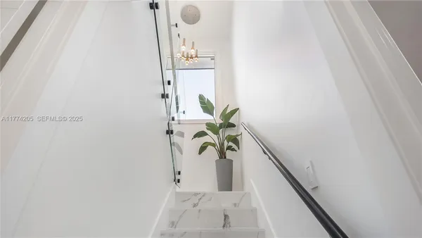 a living room with furniture potted plant and a large window