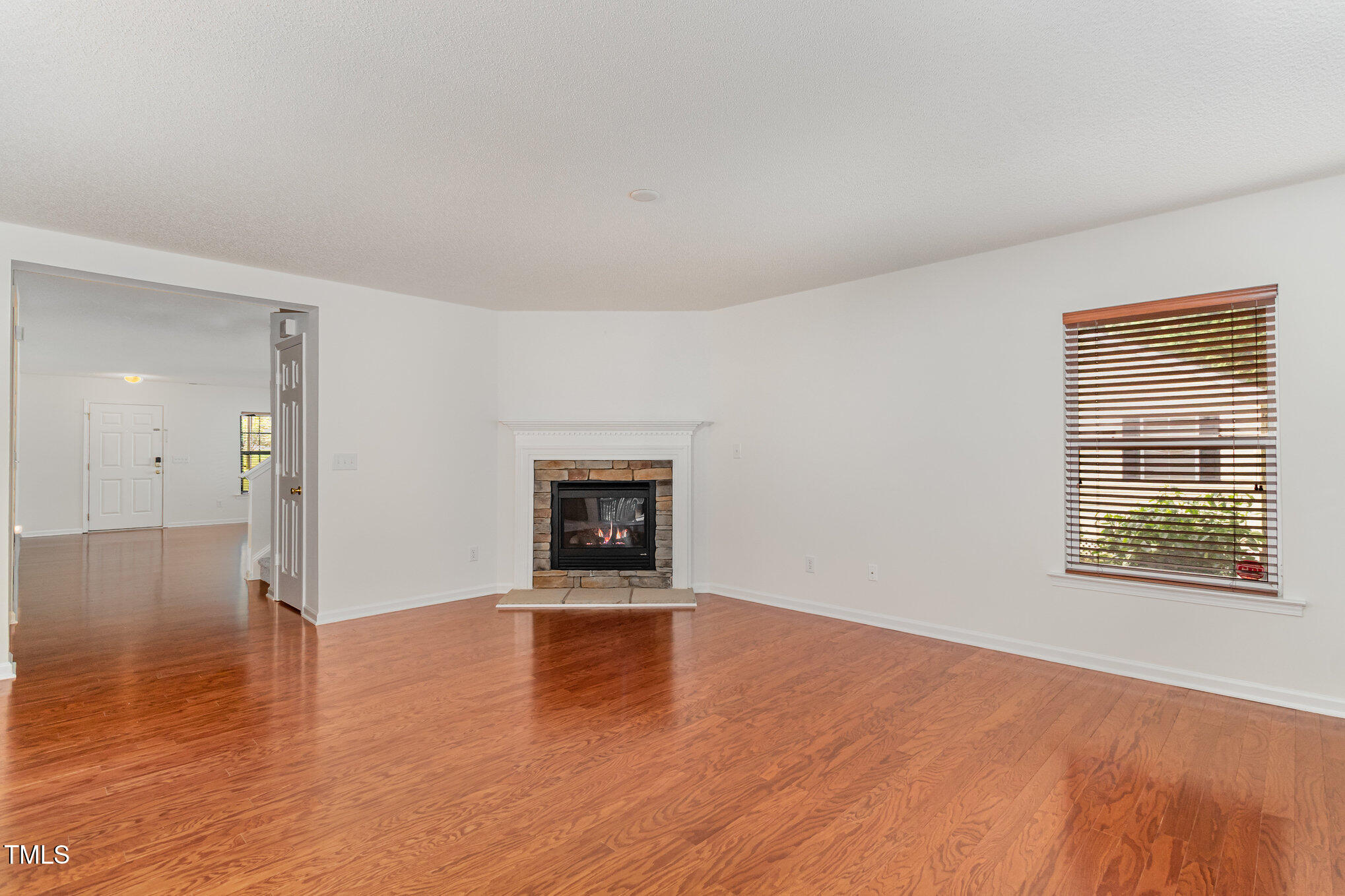 5404 Meryton Park Way Raleigh, NC 27616 - Photo 11 of 35 a view of an empty room with window and wooden floor