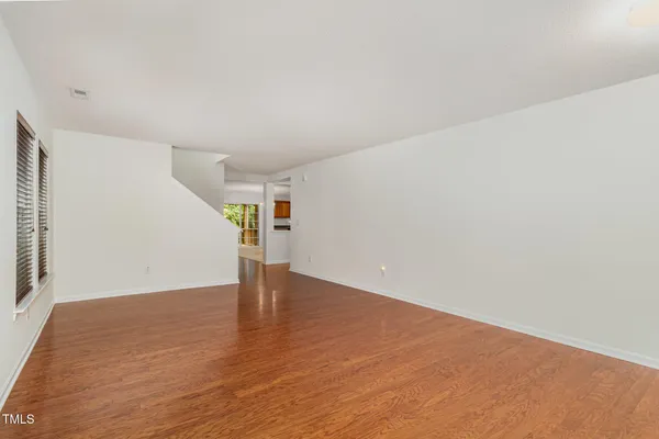 a view of empty room with wooden floor