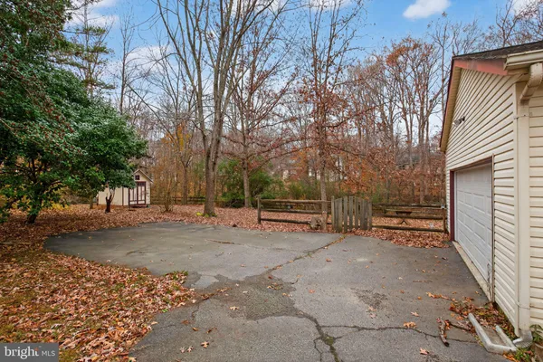 a view of a house with a bench in a backyard