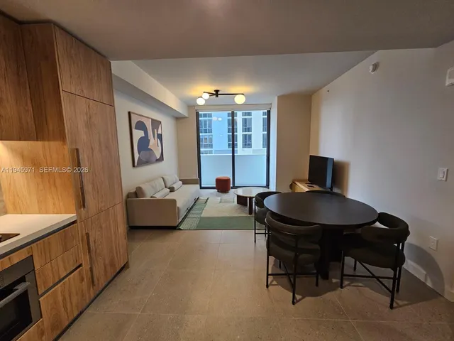 a large kitchen with stainless steel appliances a large window in it