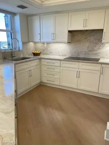 a kitchen with granite countertop white cabinets and white stainless steel appliances