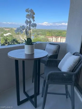 a dining room with furniture and a floor to ceiling window
