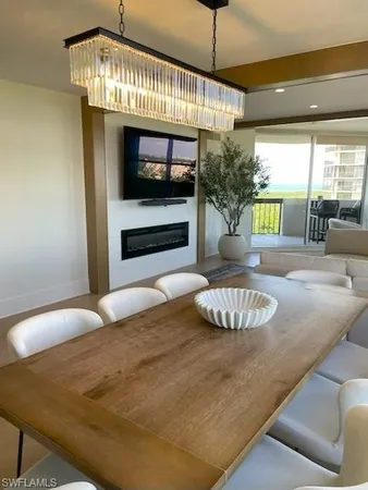 a living room with fireplace furniture a flat screen tv and a large window