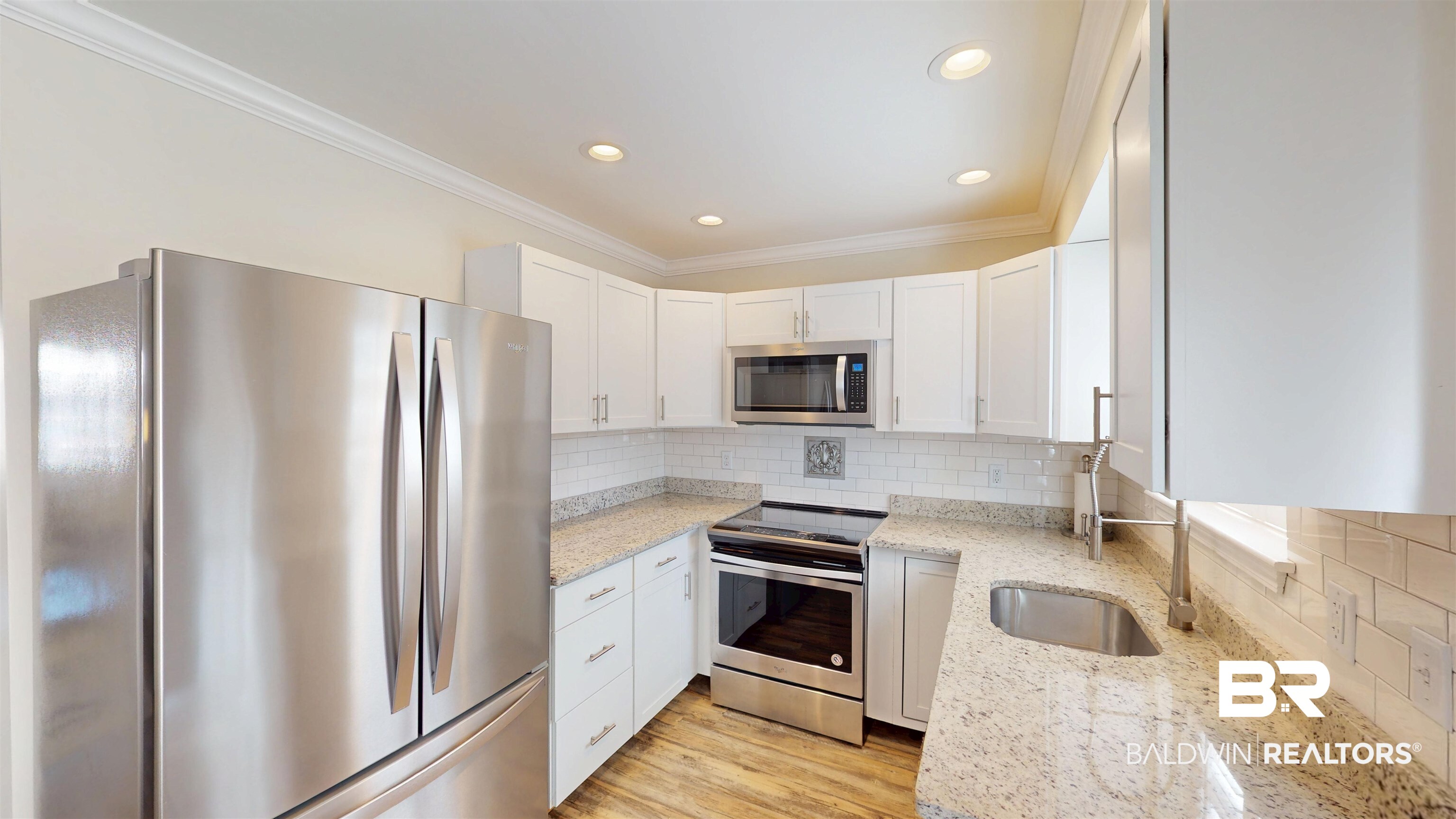 100 Du Rhu Drive, Unit J Mobile, AL 36608 - Photo 11 of 17 Kitchen featuring stainless steel appliances, white cabinetry, light stone counters, ornamental molding, and tasteful backsplash