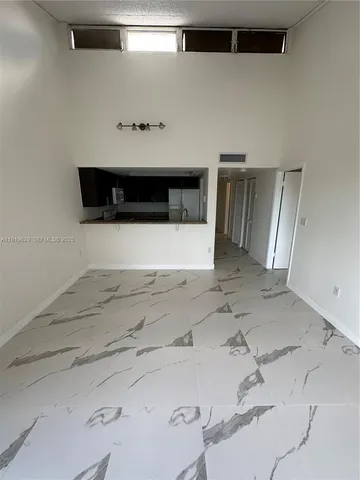 a living room with a bed and a refrigerator