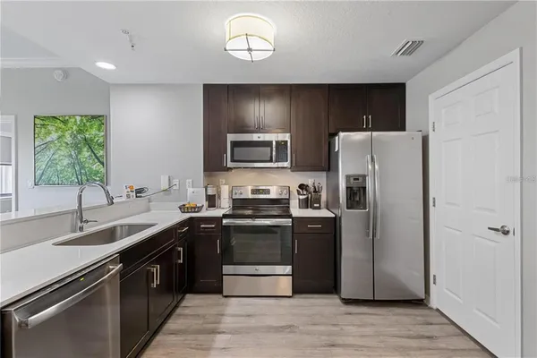 a kitchen with stainless steel appliances granite countertop a sink stove and refrigerator