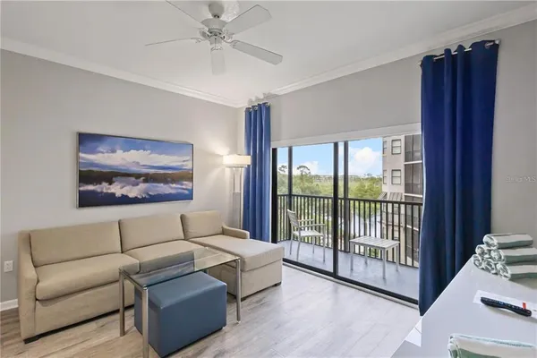 a living room with furniture a ceiling fan and a window