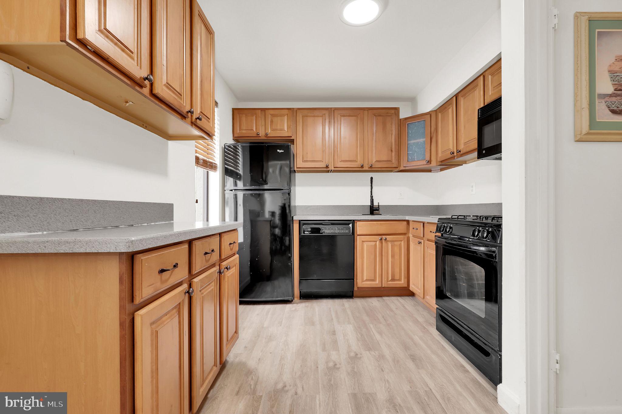 9645 White Acre Road, Unit A2 Columbia, MD 21045 - Photo 11 of 25 a kitchen with stainless steel appliances granite countertop a refrigerator a stove and a sink with cabinets