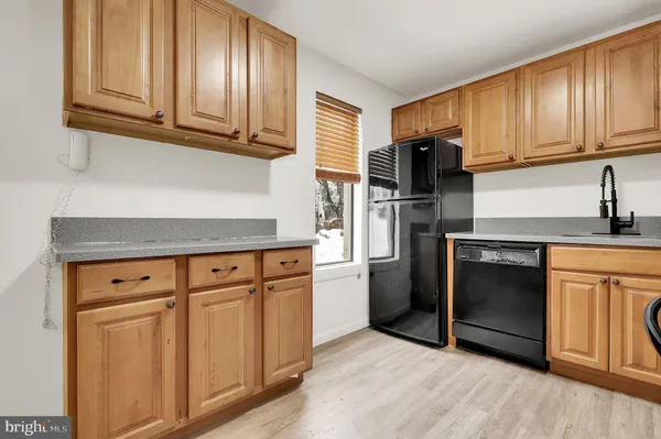 a kitchen with granite countertop cabinets stainless steel appliances and wooden floor
