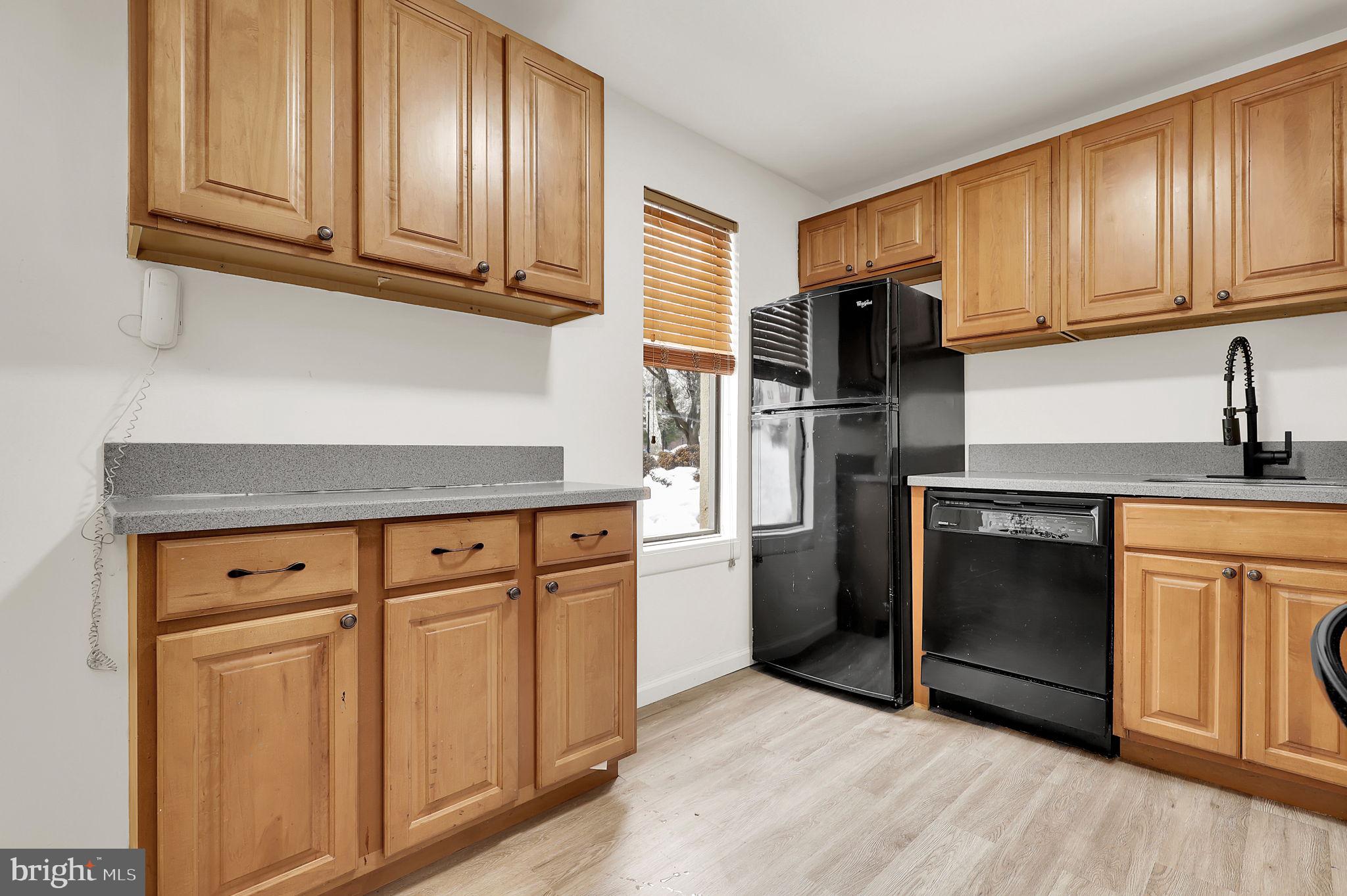9645 White Acre Road, Unit A2 Columbia, MD 21045 - Photo 12 of 25 a kitchen with granite countertop cabinets stainless steel appliances and wooden floor