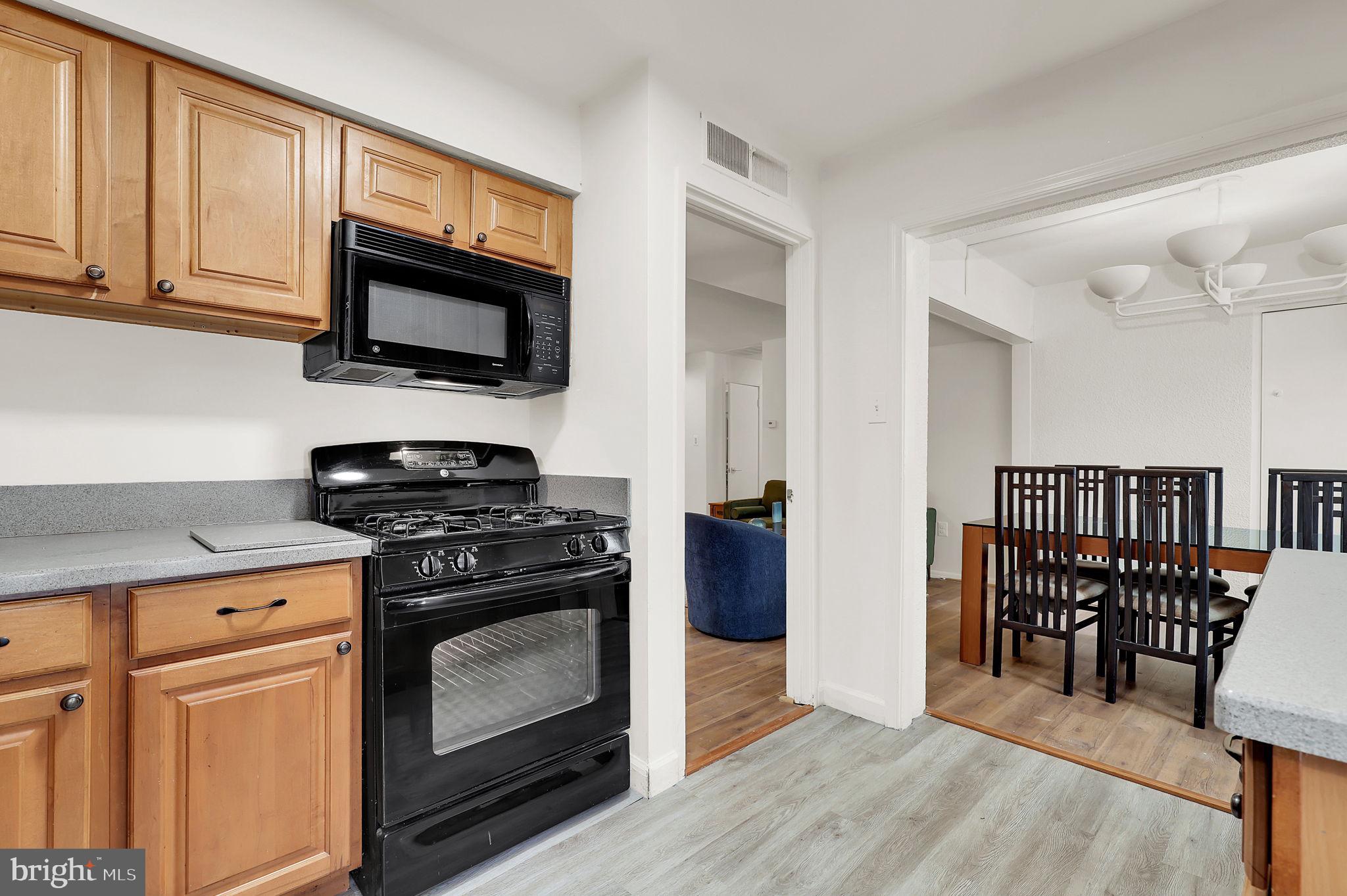 9645 White Acre Road, Unit A2 Columbia, MD 21045 - Photo 13 of 25 a kitchen with stainless steel appliances granite countertop a stove microwave and sink