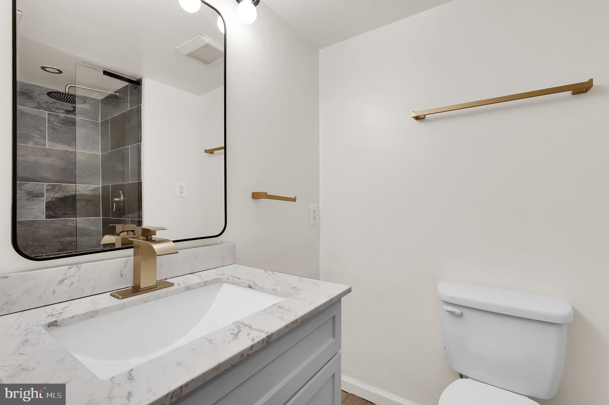 9645 White Acre Road, Unit A2 Columbia, MD 21045 - Photo 16 of 25 a bathroom with a granite countertop sink and a mirror
