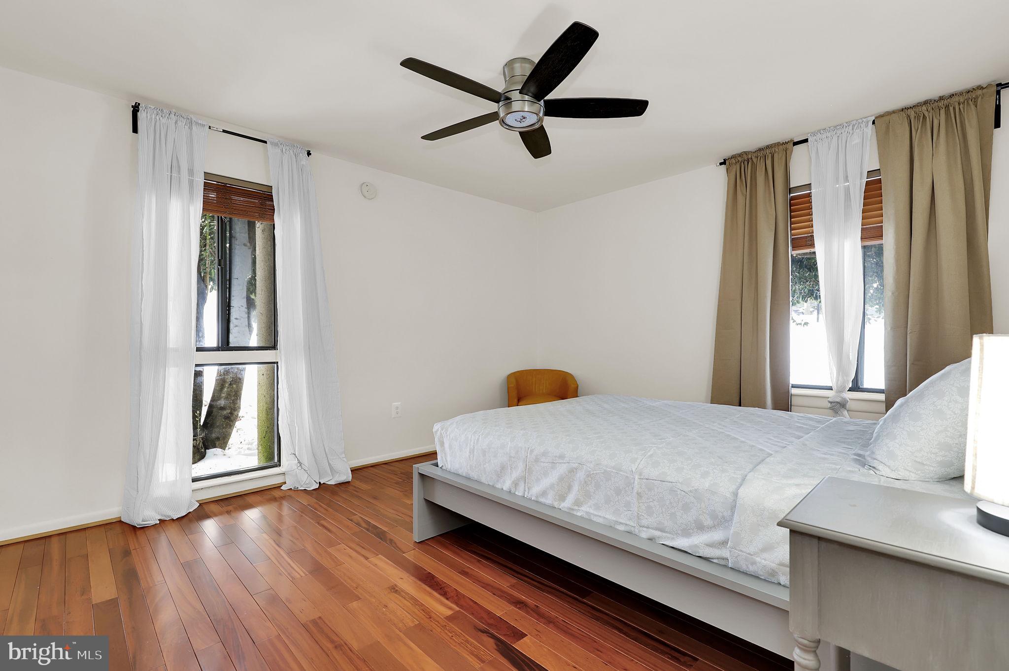 9645 White Acre Road, Unit A2 Columbia, MD 21045 - Photo 17 of 25 a bedroom with a bed and wooden floor