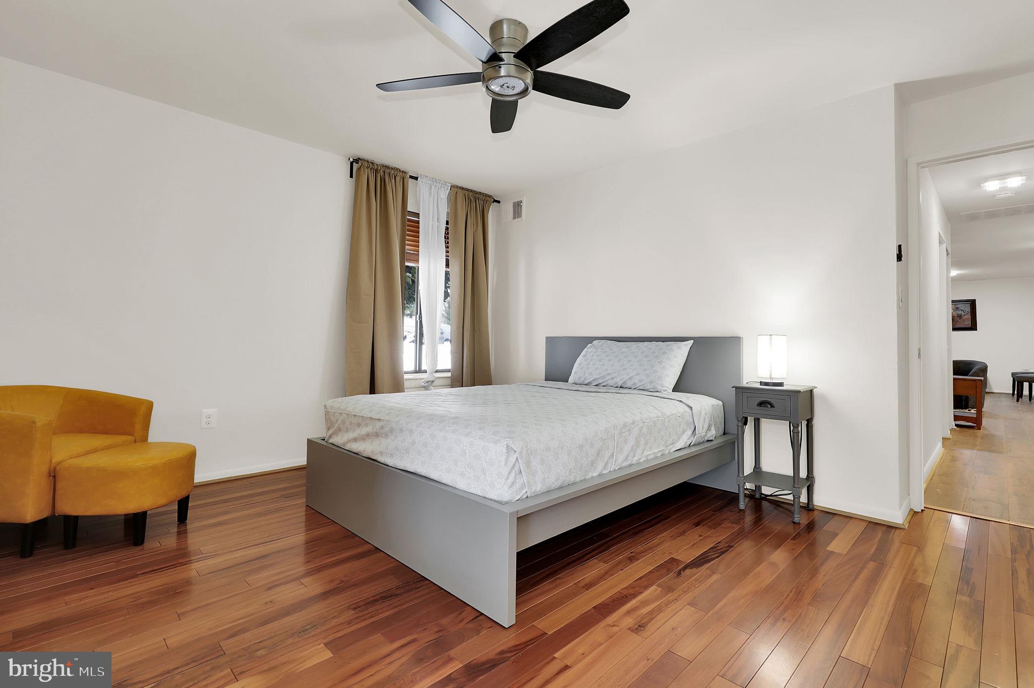 9645 White Acre Road, Unit A2 Columbia, MD 21045 - Photo 18 of 25 a bedroom with a bed and blue chair