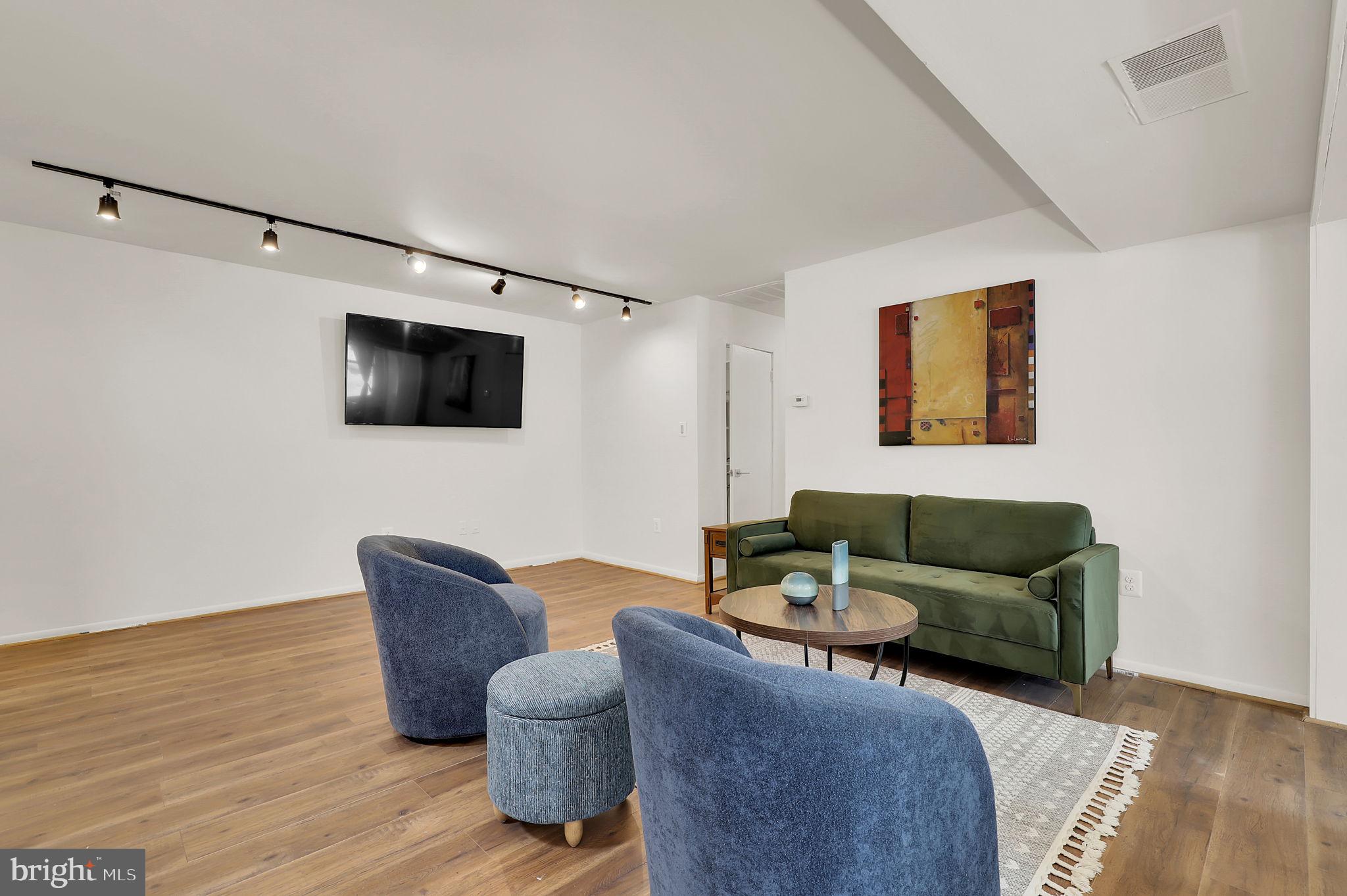 9645 White Acre Road, Unit A2 Columbia, MD 21045 - Photo 8 of 25 a living room with furniture and a flat screen tv