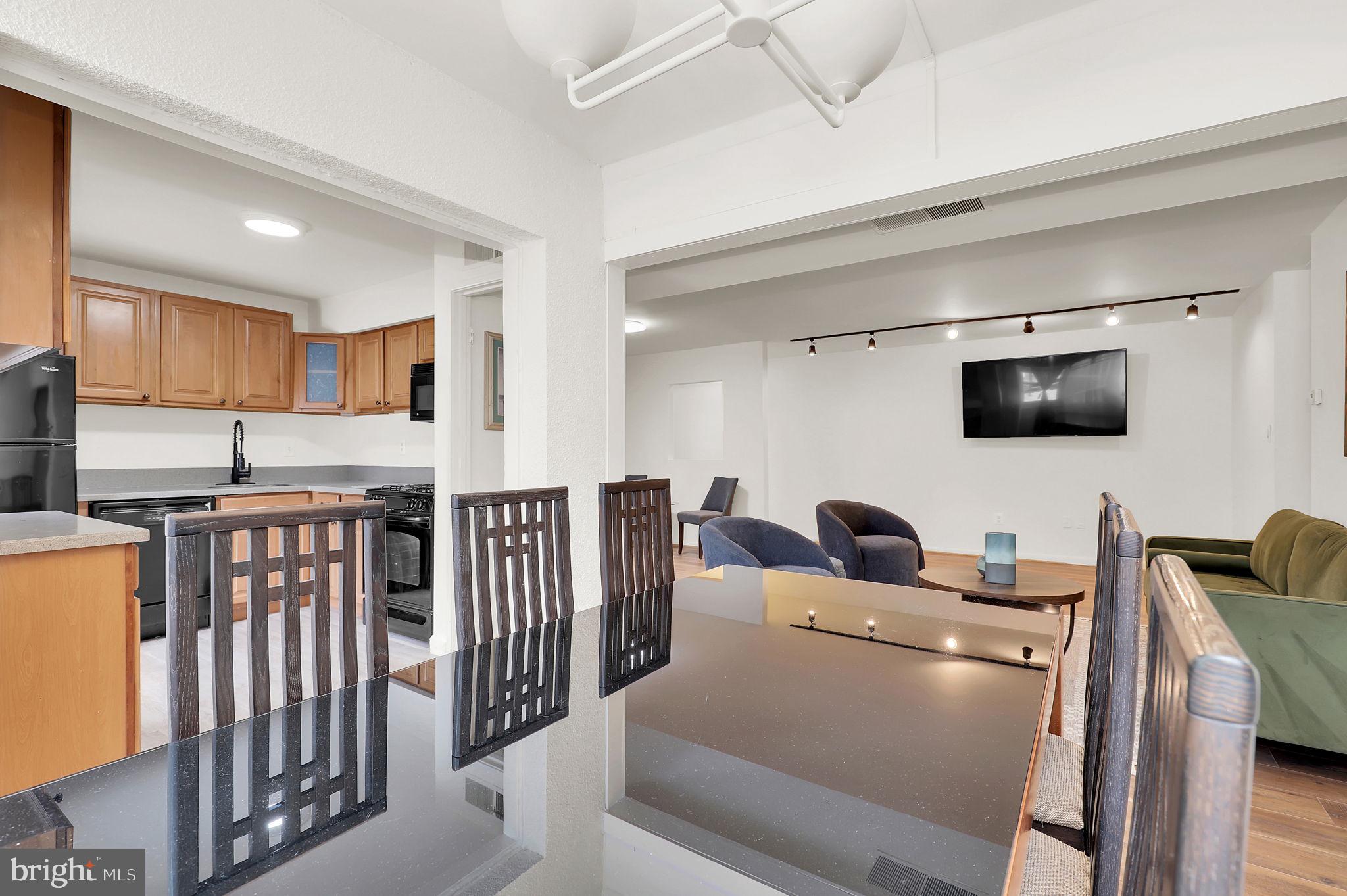 9645 White Acre Road, Unit A2 Columbia, MD 21045 - Photo 10 of 25 a living room with furniture and a flat screen tv