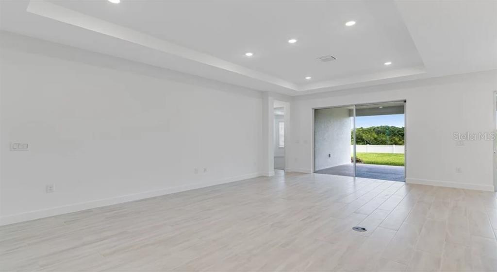 899 Arbor Grn Trail St. Cloud, FL 34771 - Photo 11 of 34 a view of an empty room with wooden floor and a window