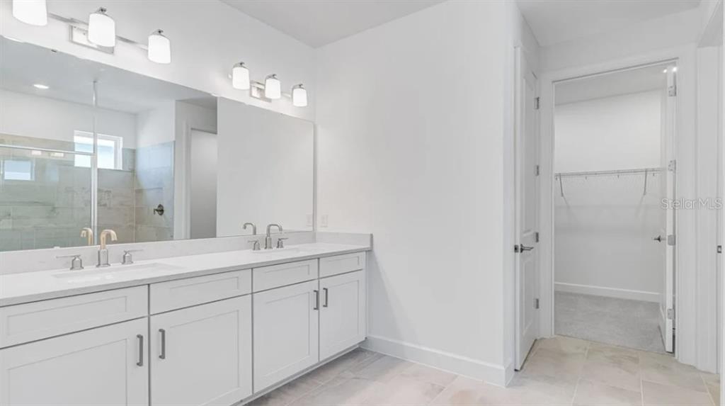 899 Arbor Grn Trail St. Cloud, FL 34771 - Photo 13 of 34 a bathroom with a double vanity sink mirror and double