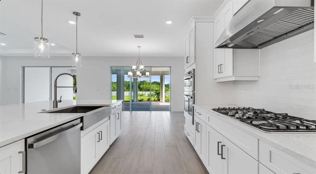 899 Arbor Grn Trail St. Cloud, FL 34771 - Photo 15 of 34 a kitchen with sink a stove and cabinets