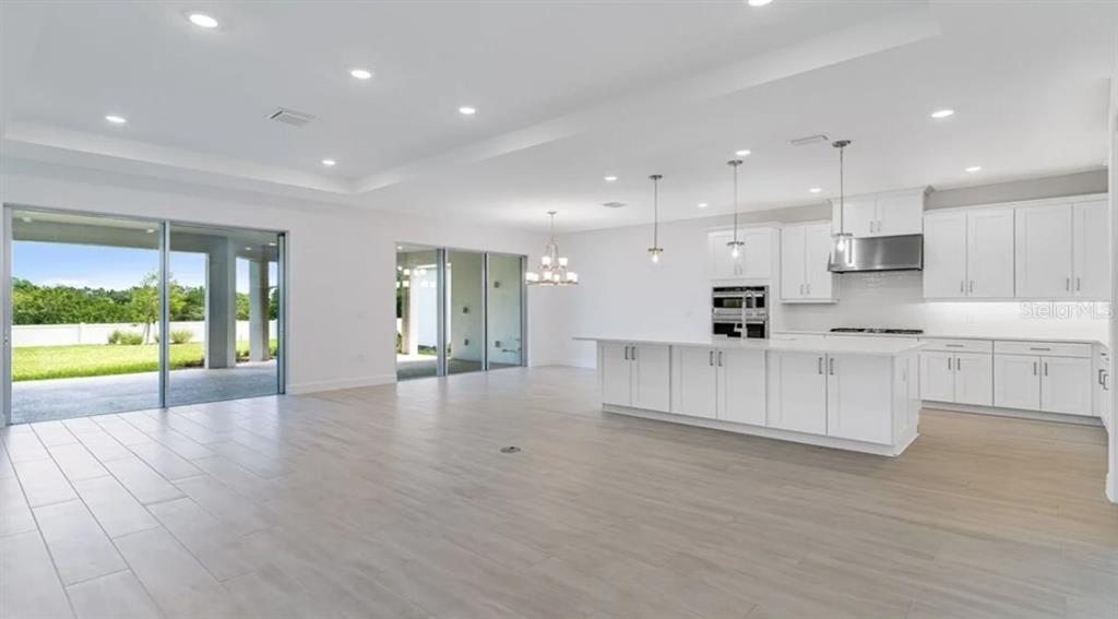 899 Arbor Grn Trail St. Cloud, FL 34771 - Photo 19 of 34 a large white kitchen with kitchen island and a large window
