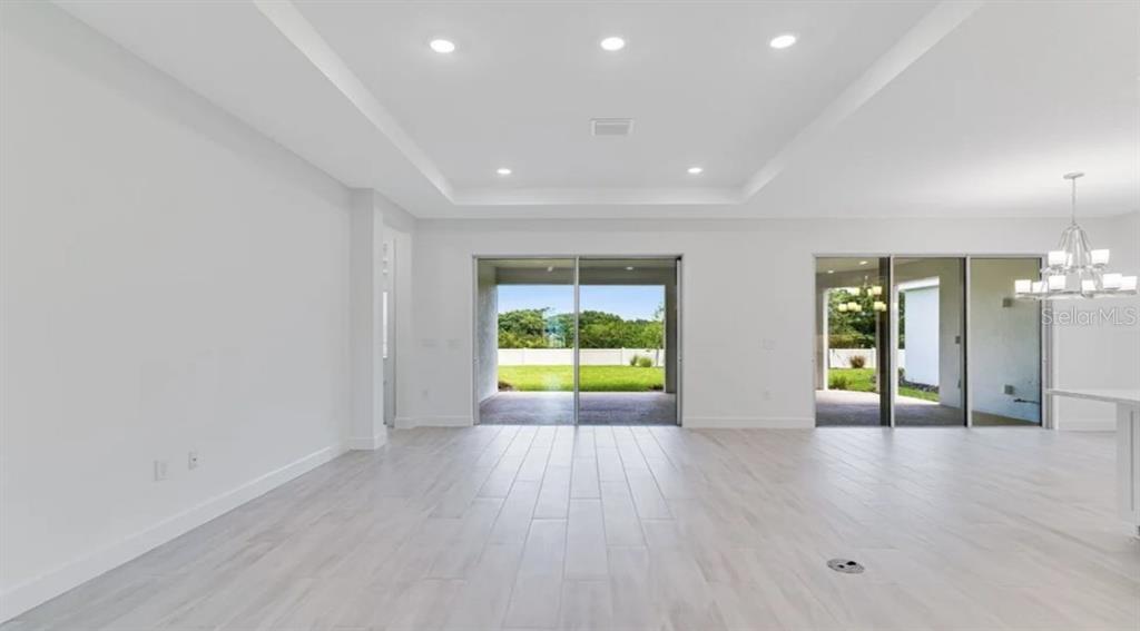 899 Arbor Grn Trail St. Cloud, FL 34771 - Photo 4 of 34 an empty room with wooden floor and windows