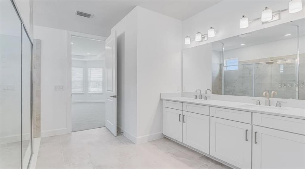 899 Arbor Grn Trail St. Cloud, FL 34771 - Photo 5 of 34 a bathroom with a double vanity sink mirror and double
