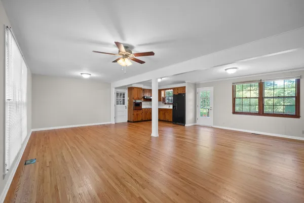a view of an empty room with window and wooden floor