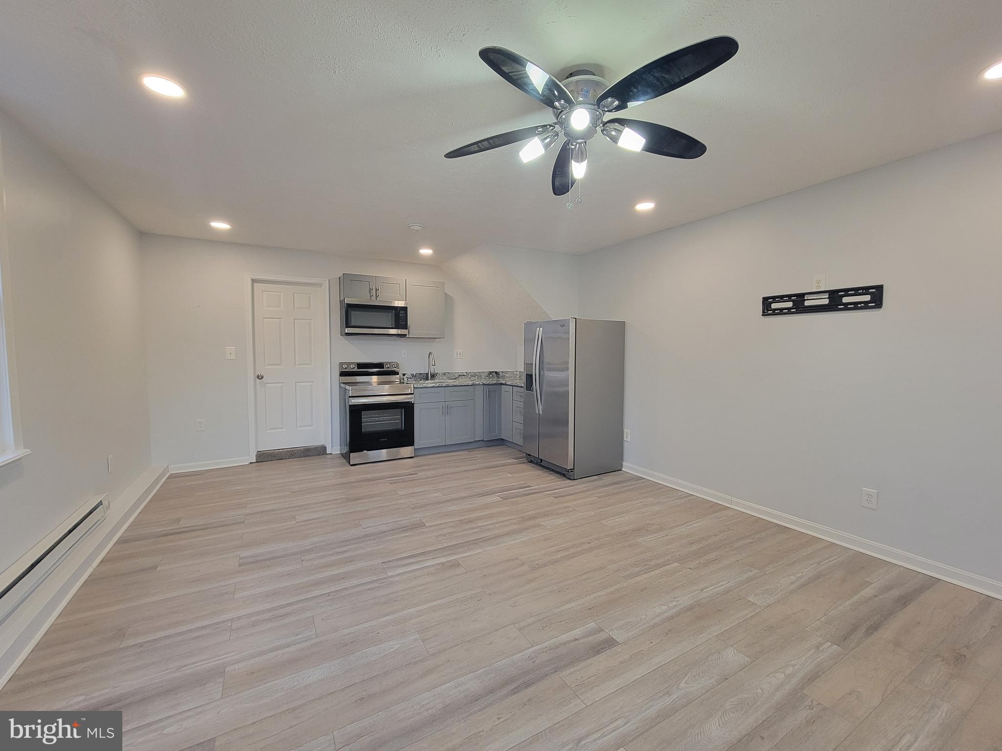 2621 North Snyder Avenue Sparrows Point, MD 21219 - Photo 43 of 65 an empty room with stainless steel appliances wooden floor and a kitchen view
