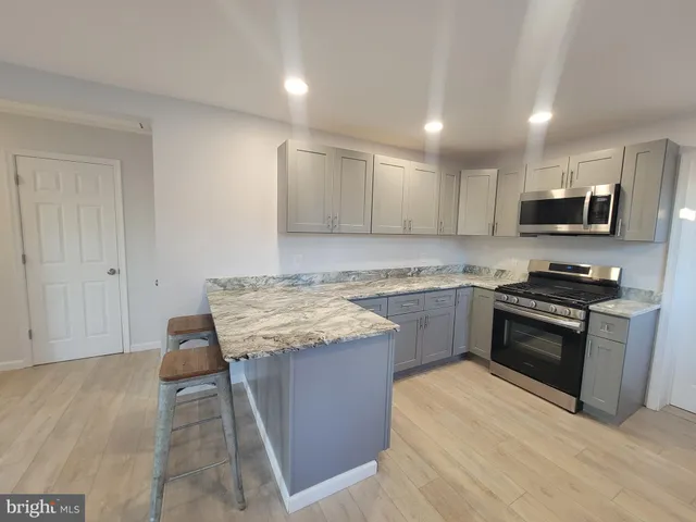 a kitchen with stainless steel appliances granite countertop a refrigerator sink and stove