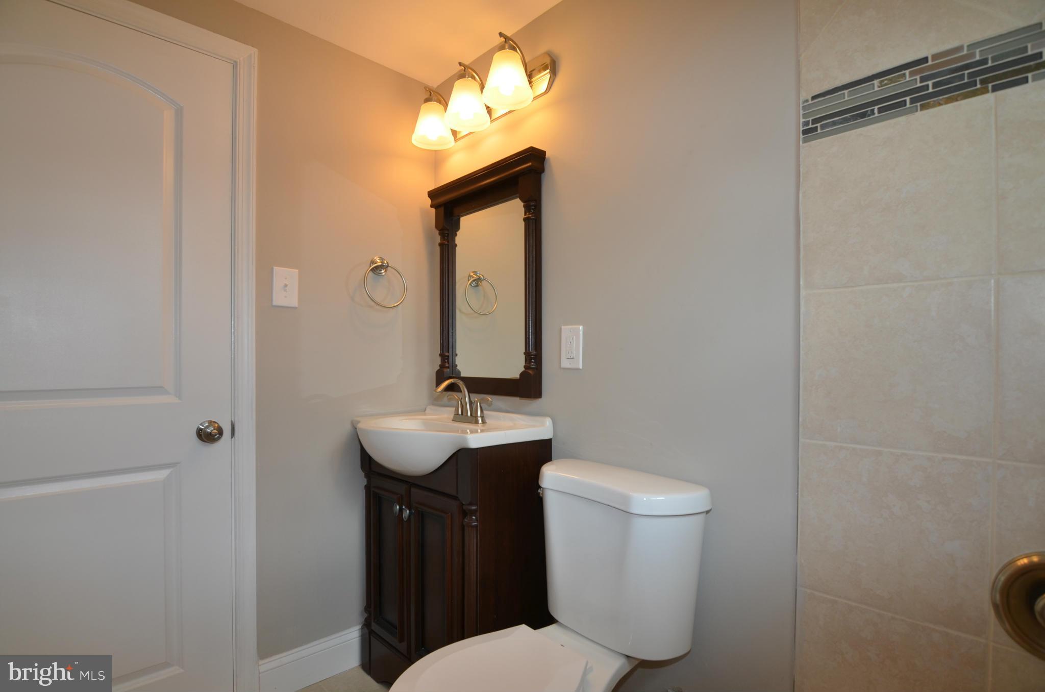 8254 Kavanagh Road Baltimore, MD 21222 - Photo 17 of 20 a bathroom with a toilet a sink and mirror