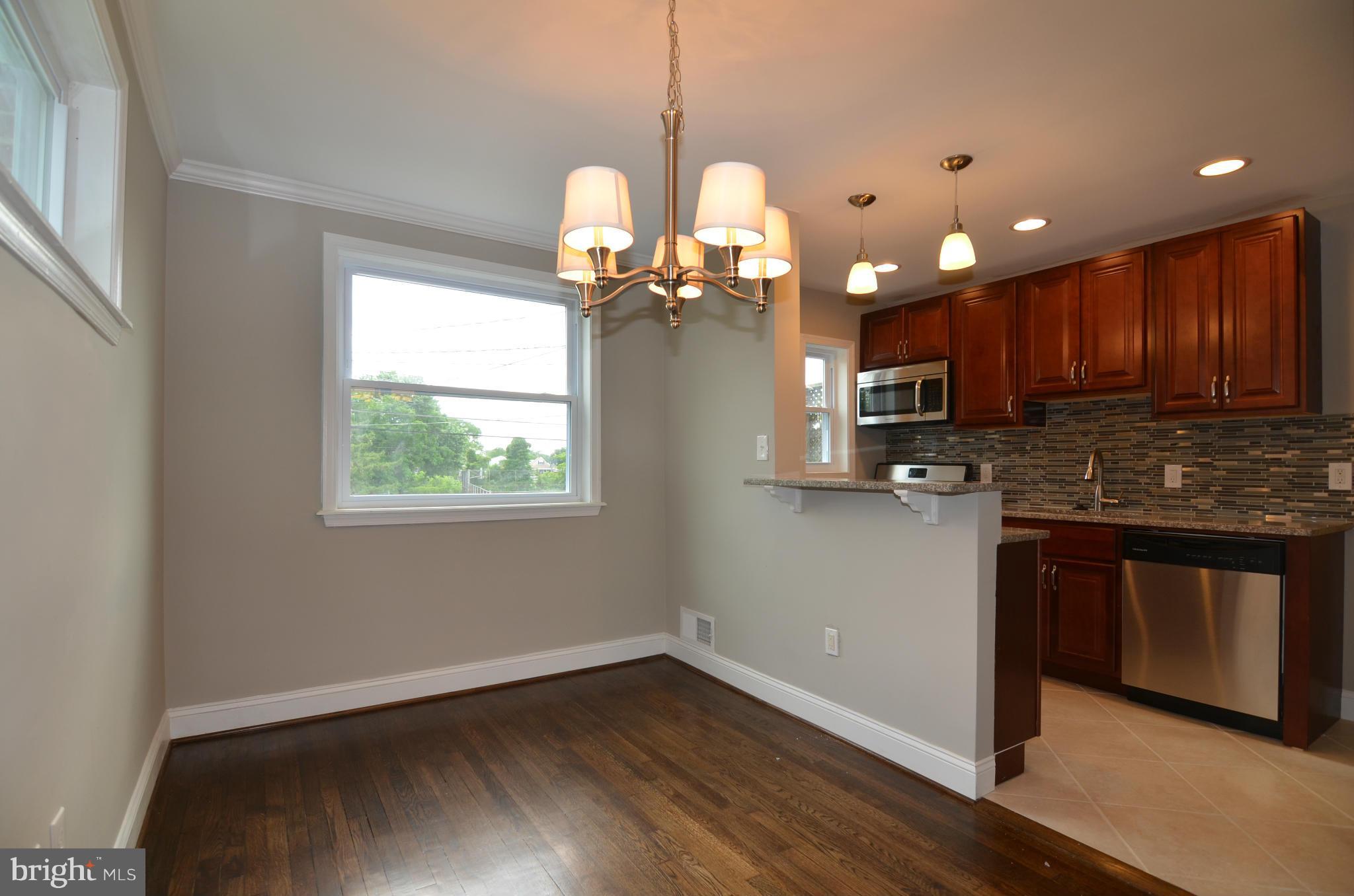 8254 Kavanagh Road Baltimore, MD 21222 - Photo 6 of 20 a kitchen with stainless steel appliances granite countertop wooden cabinets a stove a sink and a window