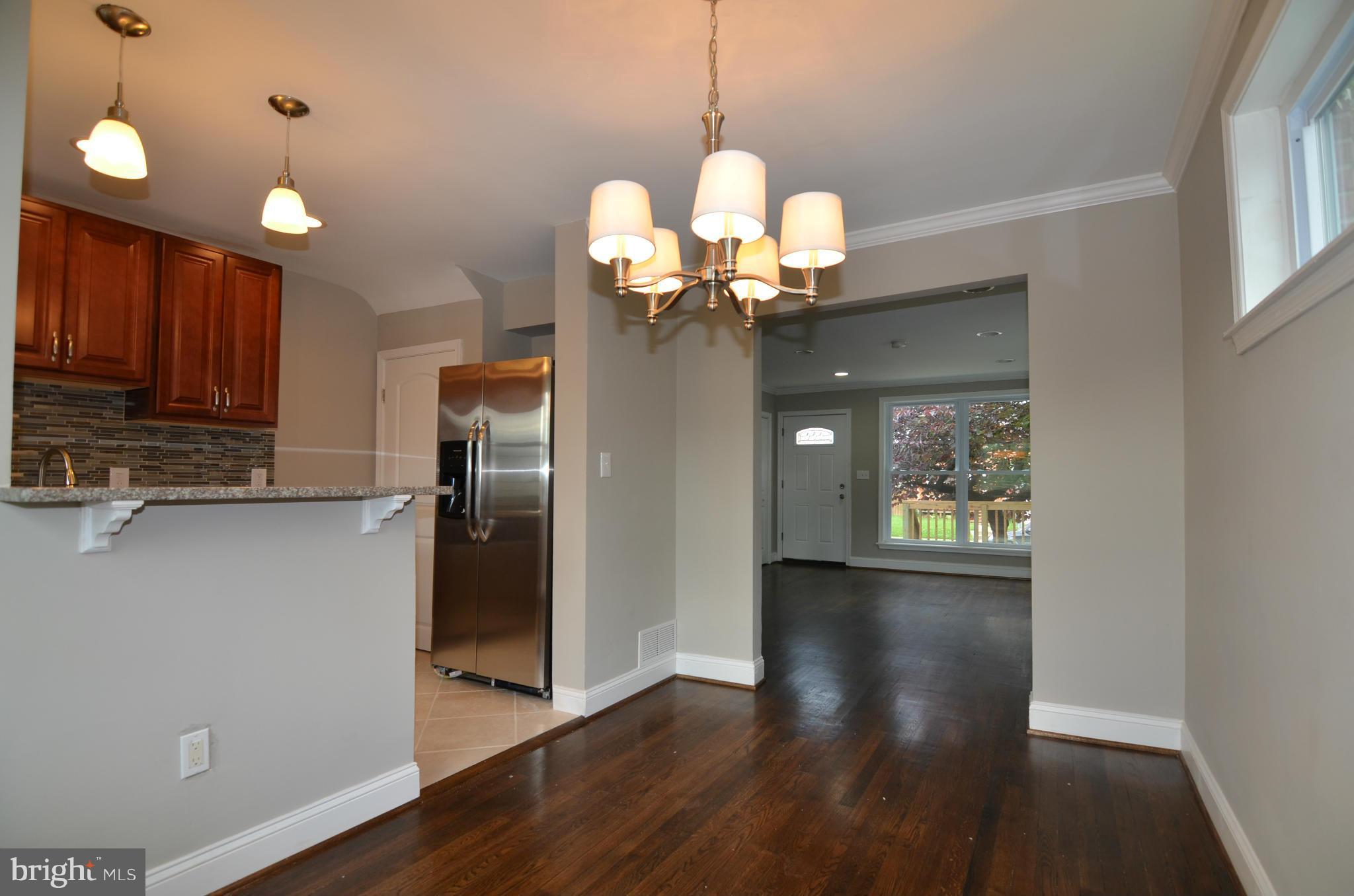8254 Kavanagh Road Baltimore, MD 21222 - Photo 7 of 20 a view of a kitchen with a refrigerator wooden floor and a ceiling fan