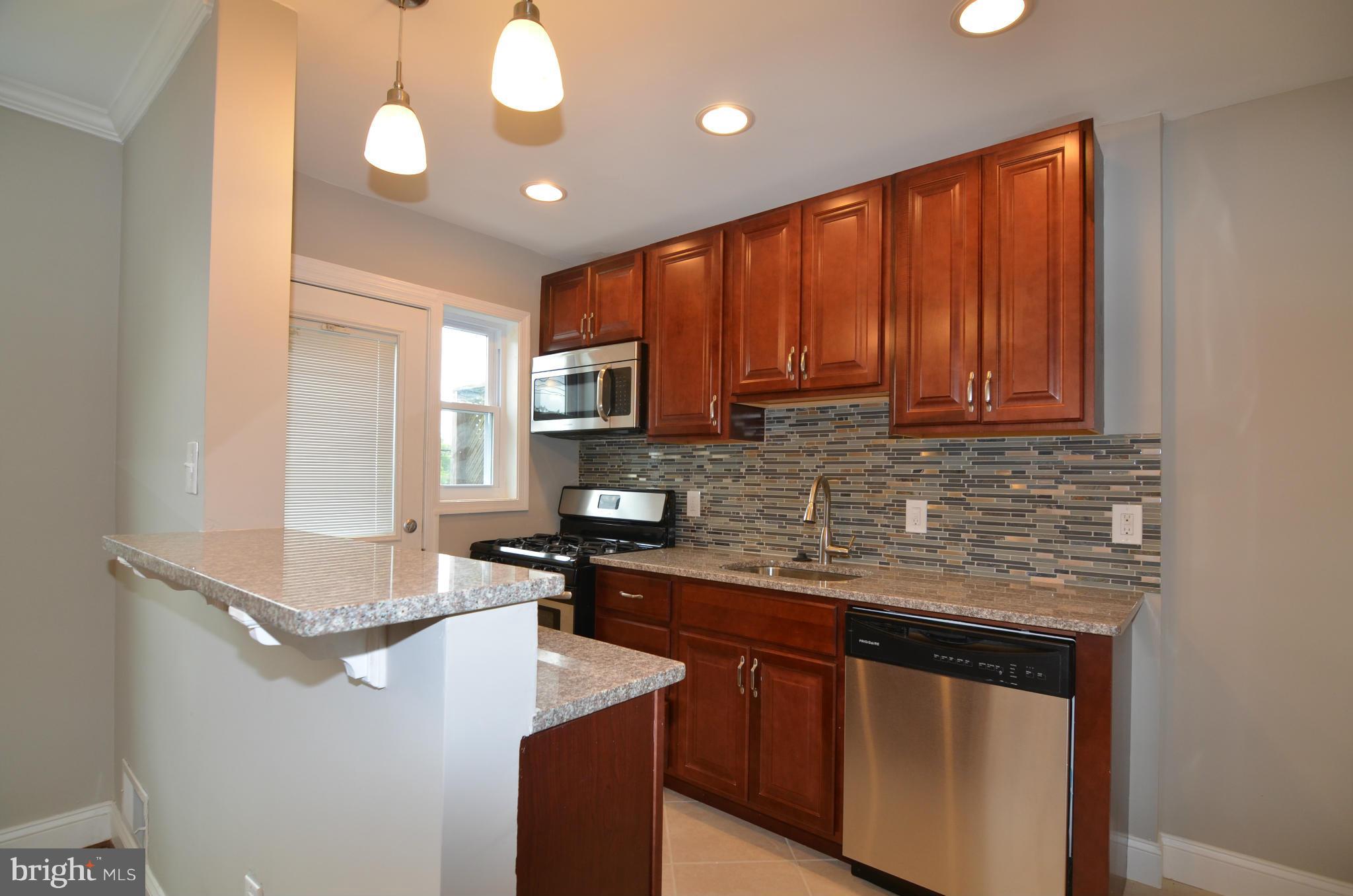 8254 Kavanagh Road Baltimore, MD 21222 - Photo 9 of 20 a kitchen with stainless steel appliances granite countertop a sink stove and microwave