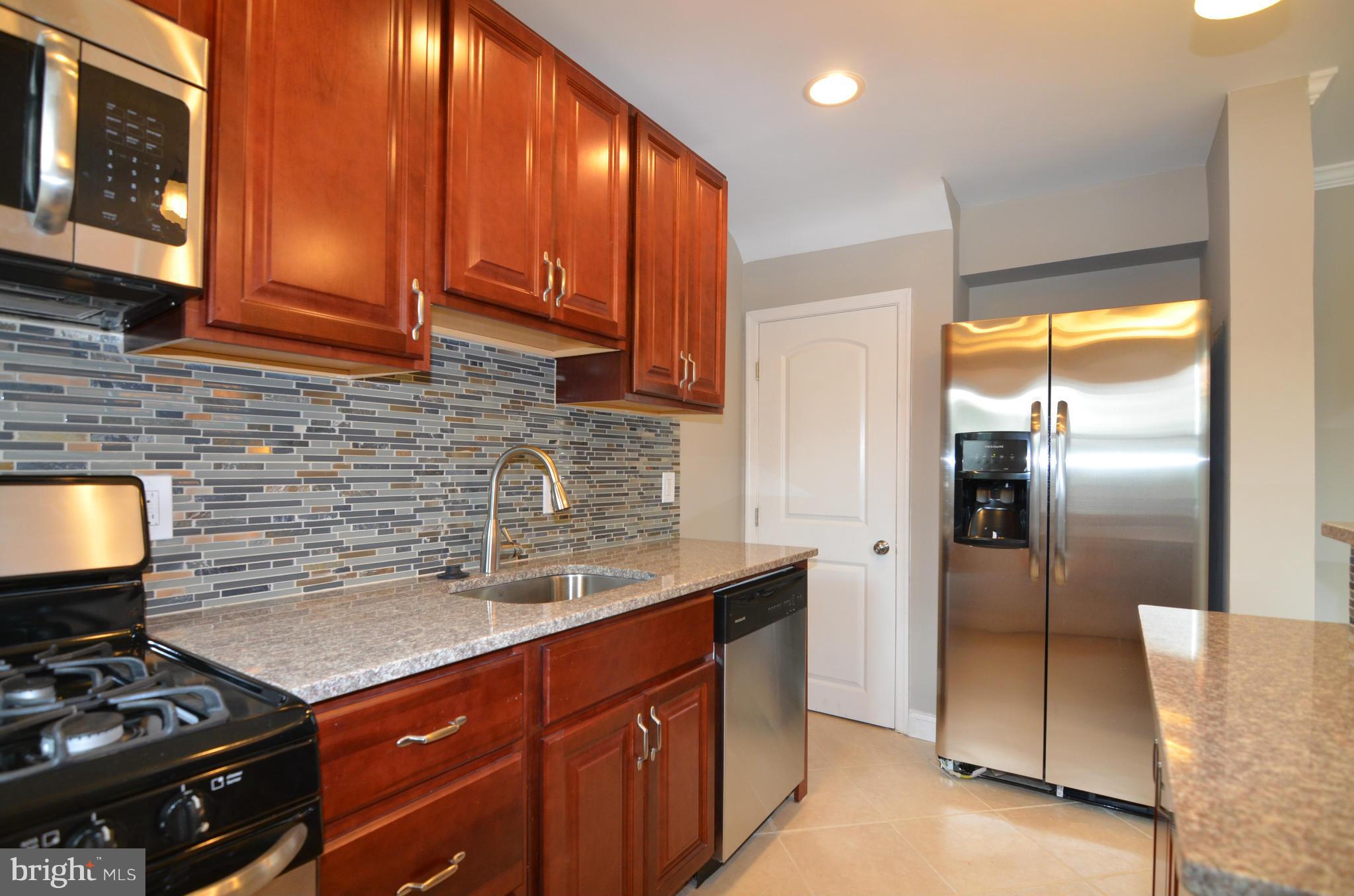 8254 Kavanagh Road Baltimore, MD 21222 - Photo 10 of 20 a kitchen with stainless steel appliances granite countertop a stove a refrigerator and a sink