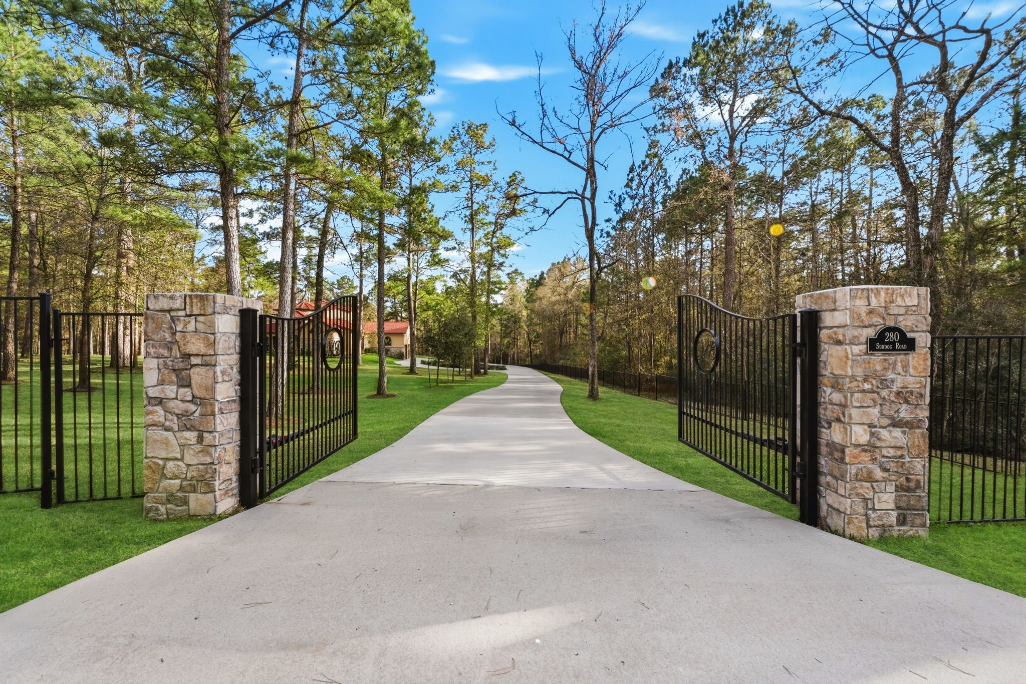 280 Sundog Road Huntsville, TX 77340 - Photo 2 of 50 Private gated entry welcomes you to the property, leading down the drive to this stunning estate nestled among the trees of Texas Grand Ranch.