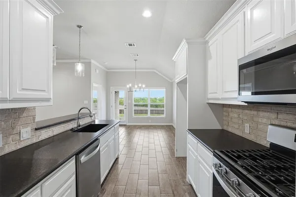 a kitchen with a sink a stove and cabinets