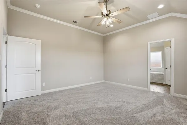 an empty room with a ceiling fan and a bathroom