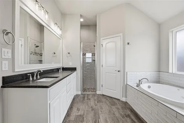 a bathroom with a granite countertop tub sink double vanity granite and a bathtub
