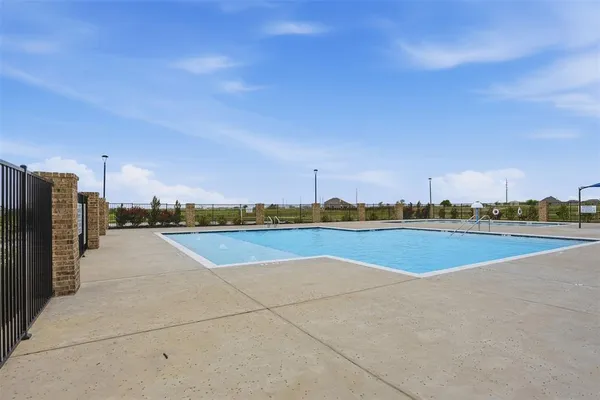 a view of a swimming pool and a couple of chairs