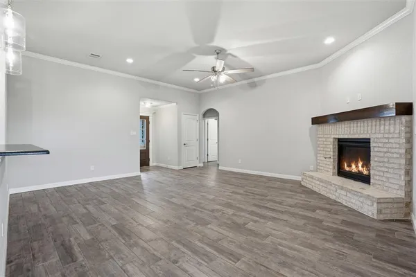 a view of an empty room with a fireplace and a window