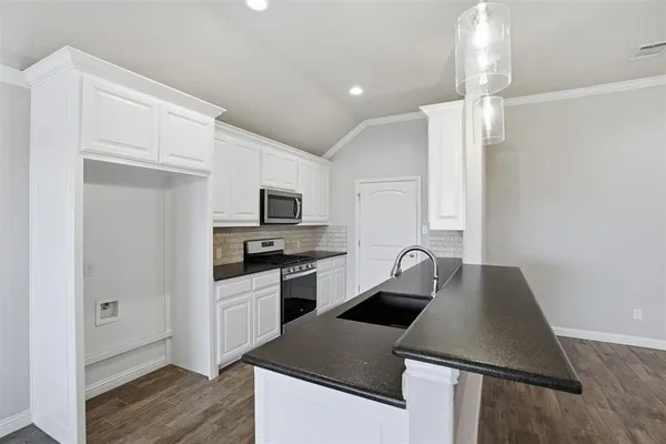 a kitchen with stainless steel appliances granite countertop a sink stove and refrigerator