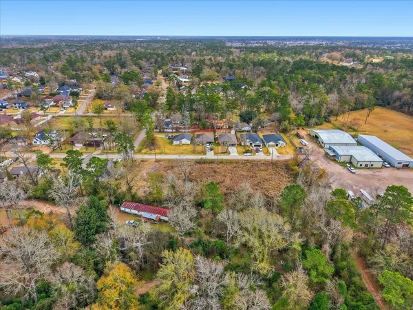 an aerial view of residential houses with outdoor space and trees