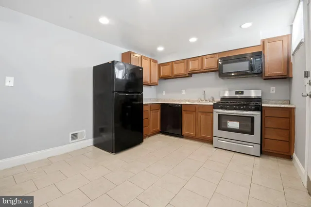 a kitchen with stainless steel appliances granite countertop a refrigerator and a stove top oven
