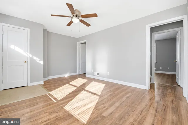 a view of a room with wooden floor and white walls