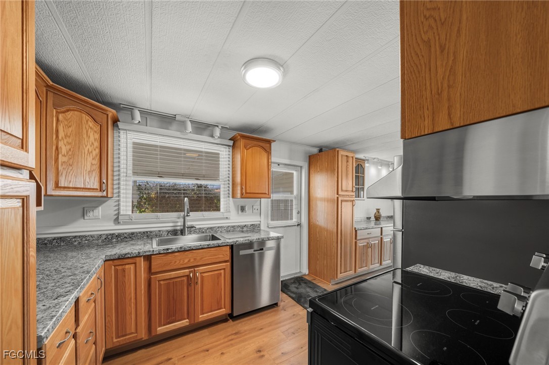 2971 York Road St. James City, FL 33956 - Photo 11 of 23 a kitchen with stainless steel appliances granite countertop a sink stove and refrigerator