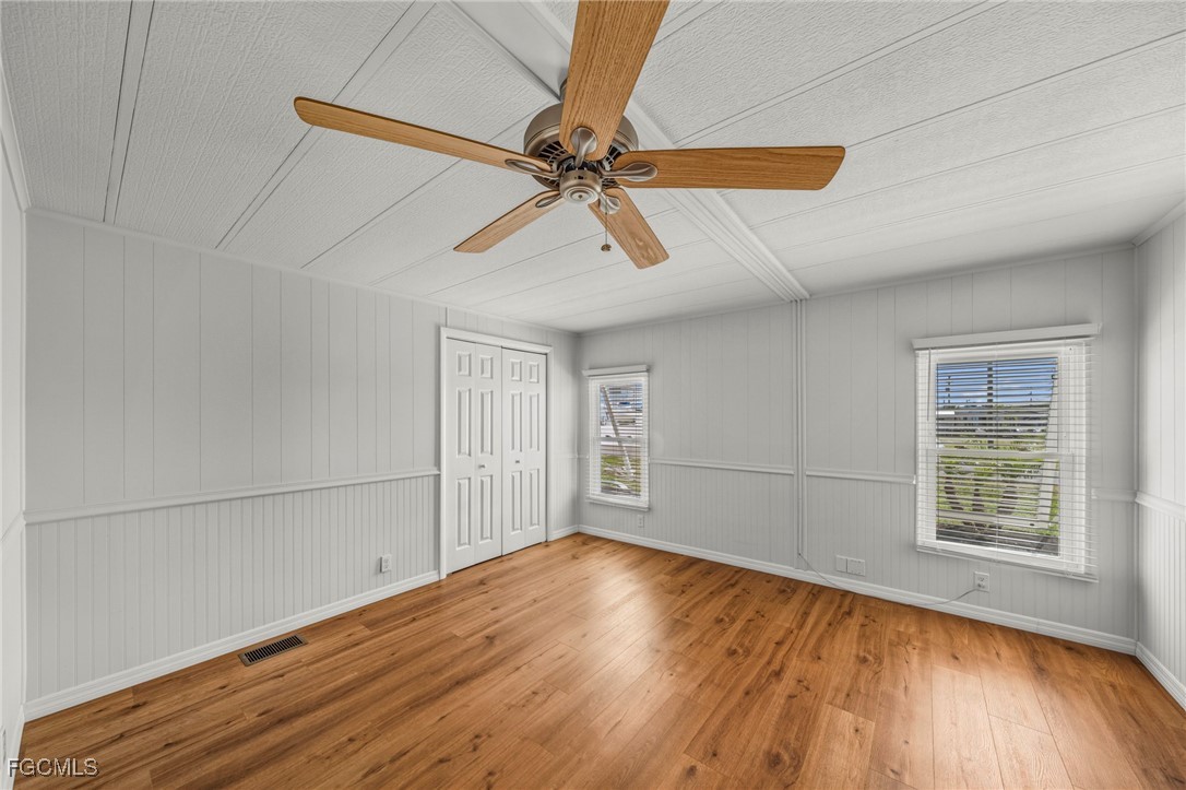 2971 York Road St. James City, FL 33956 - Photo 12 of 23 an empty room with wooden floor fan and windows