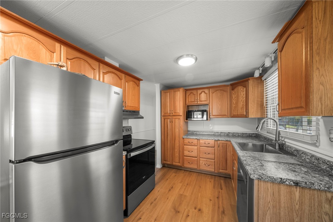 2971 York Road St. James City, FL 33956 - Photo 3 of 23 a kitchen with granite countertop stainless steel appliances a refrigerator sink and cabinets