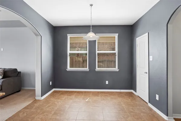 a view of an empty room with window and cabinet